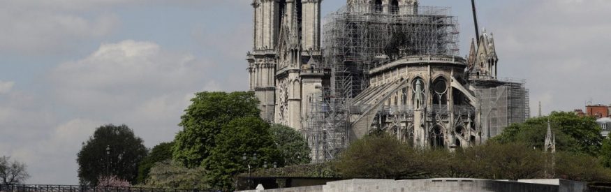 Fire fighters are at work on top of a tower of Notre-Dame Cathedral, as a crane lifts up construction material in Paris on April 17, 2019, two days after a fire that devastated the building in the centre of the French capital. - French President vowed on April 16 to rebuild Notre-Dame cathedral "within five years", after a fire which caused major damage to the 850-year-old Paris landmark. (Photo by Thomas SAMSON / AFP)